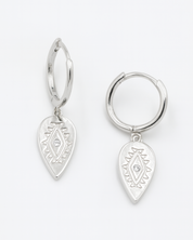 Pair of silver hoop earrings with teardrop-shaped dangling charms on a white background