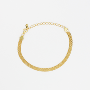 A gold-colored bracelet with a mesh chain design on a white background.