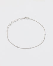 A silver bracelet with small spherical embellishments, displayed against a white background.