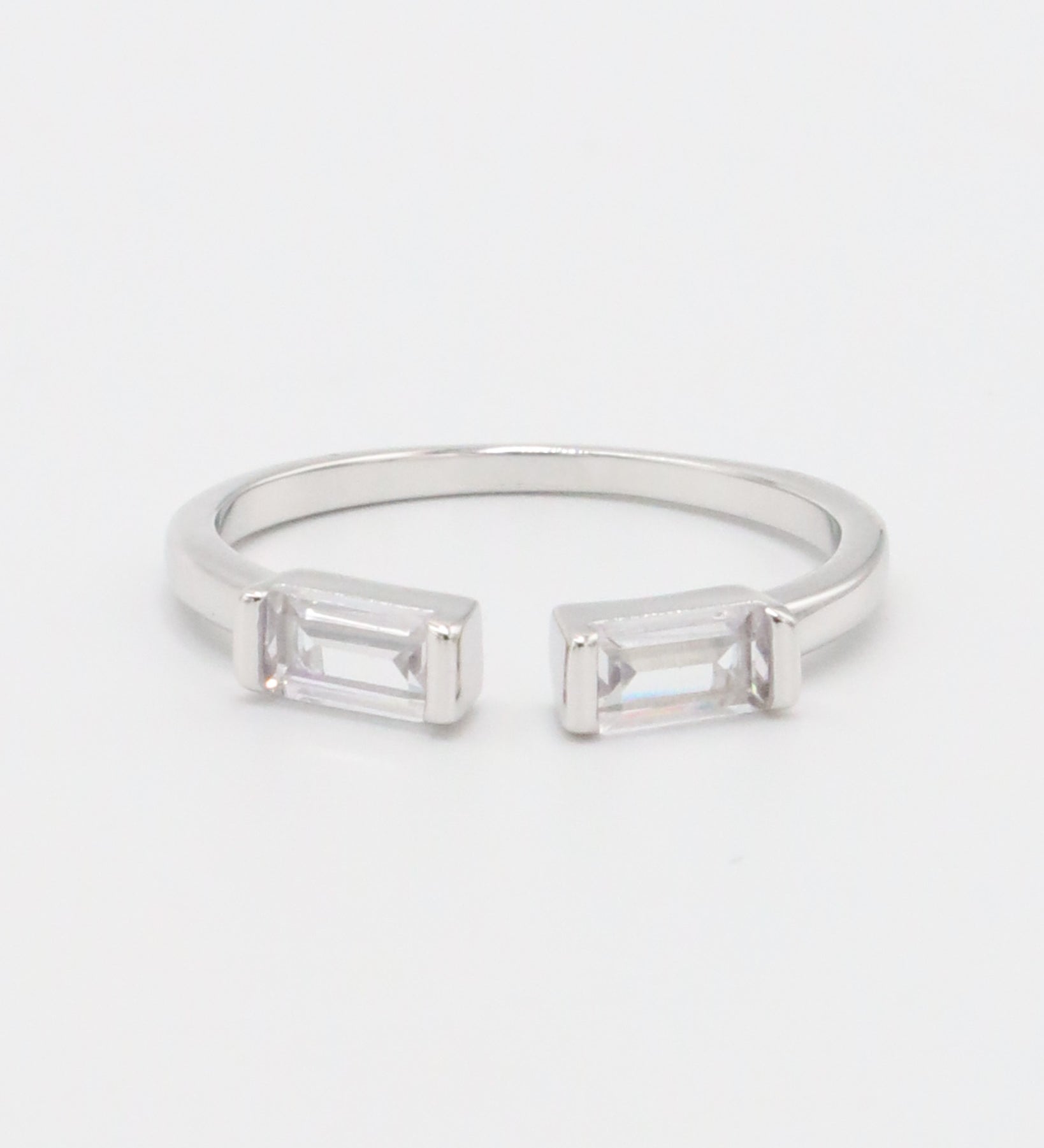 A silver ring with two square-cut clear crystals set in a classic six-prong setting