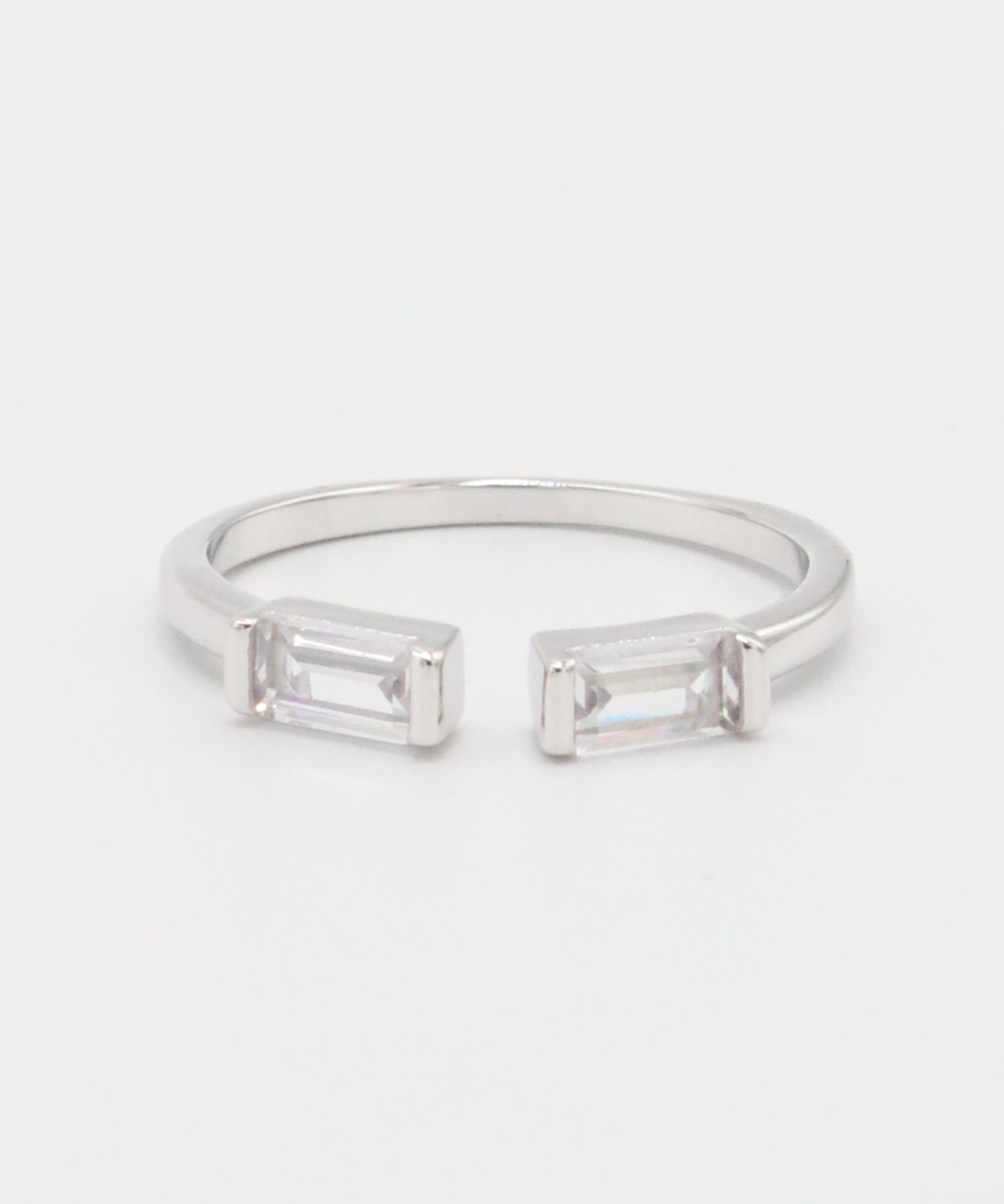 A silver ring with two square-cut clear crystals set in a classic six-prong setting