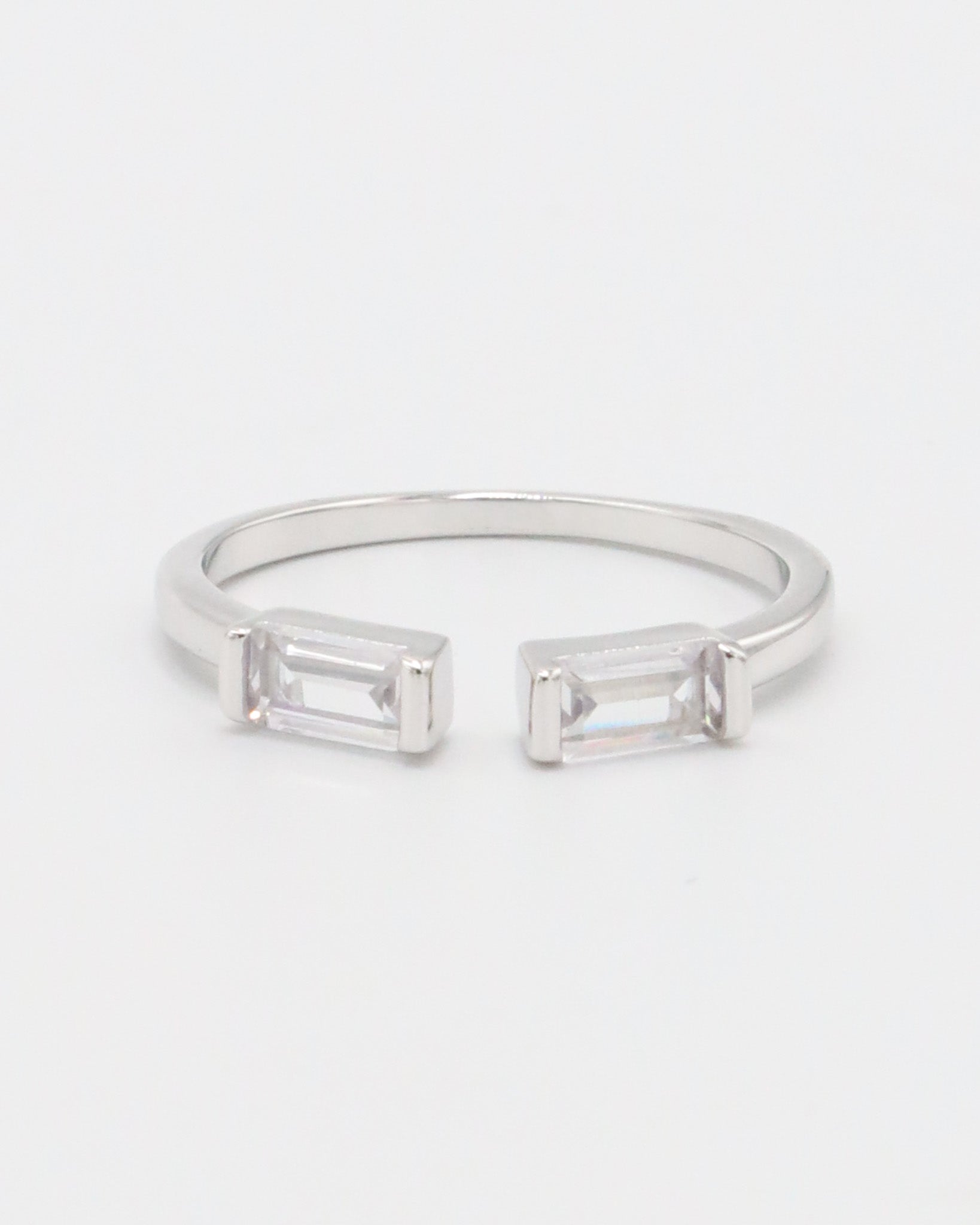 A silver ring with two square-cut clear crystals set in a classic six-prong setting