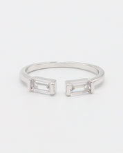 A silver ring with two square-cut clear crystals set in a classic six-prong setting