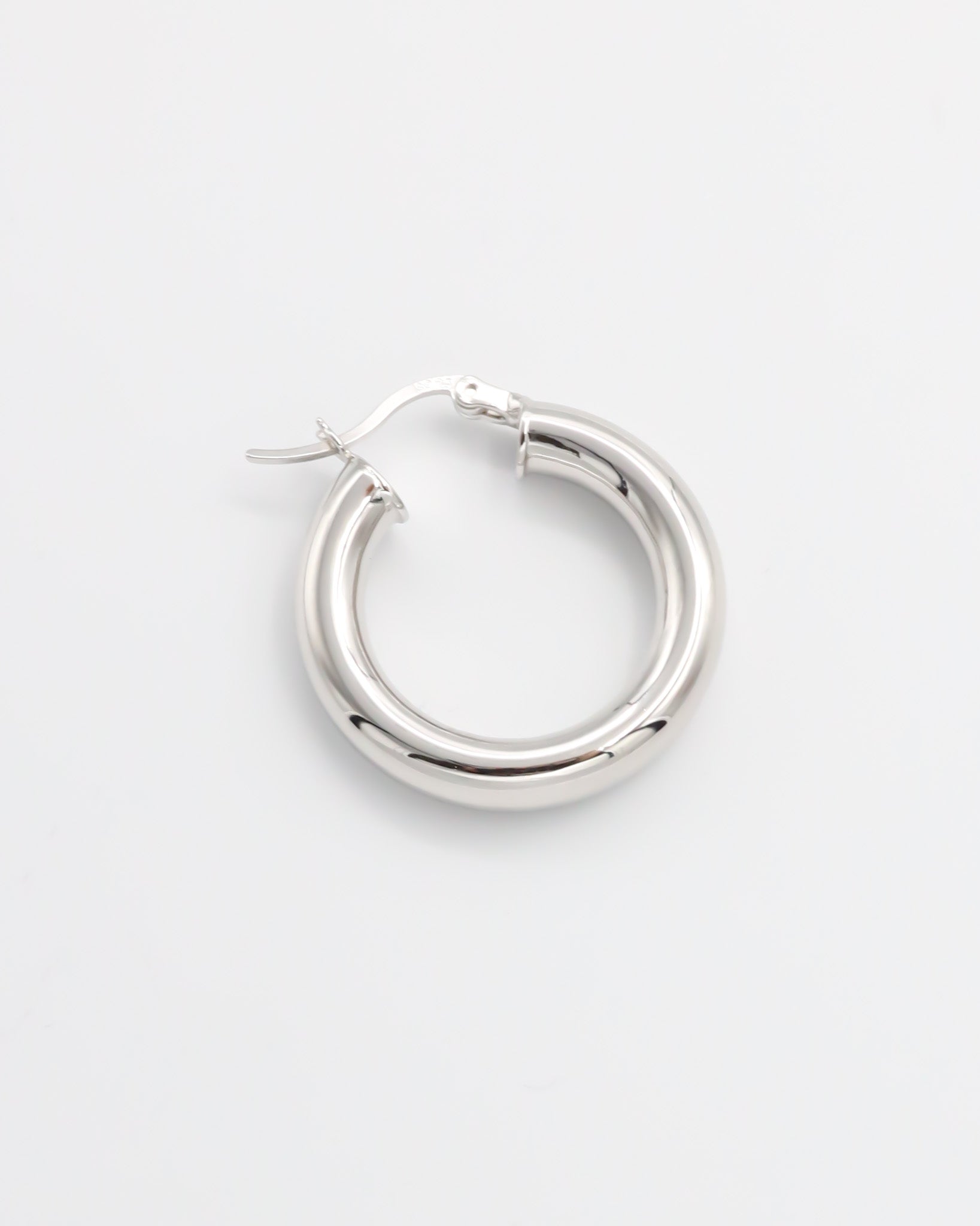 A pair of silver hoop earrings with a latch back closure, displayed against a white background.