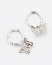 A silver hoop earring with a butterfly charm attached to it, displayed on a white background.