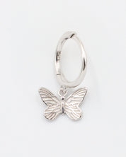 A silver hoop earring with a butterfly charm attached to it, displayed on a white background.