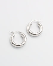 A pair of silver hoop earrings with a latch back closure mechanism, displayed on a white background.