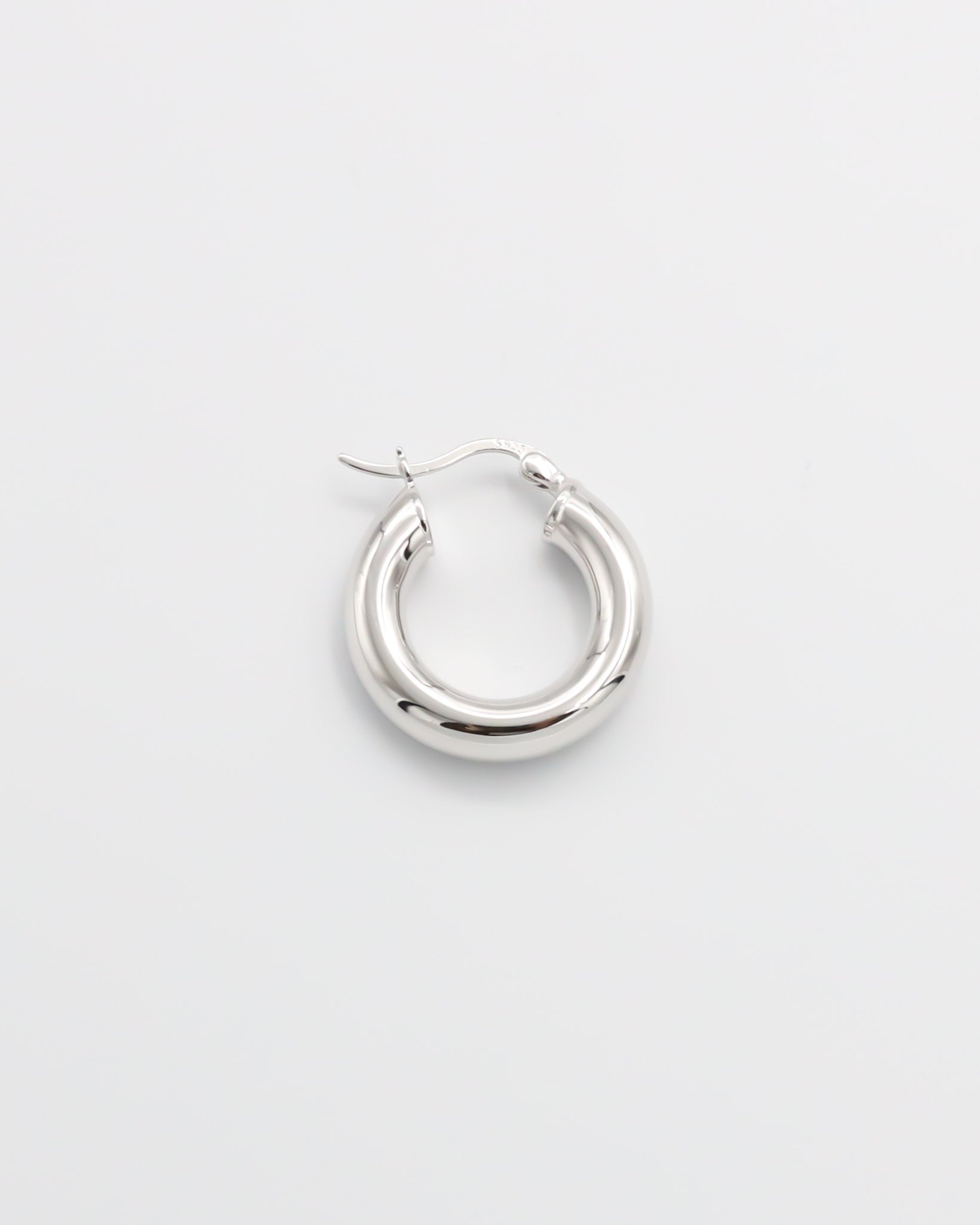 A single silver hoop earring with a latch back closure mechanism, displayed on a white background.