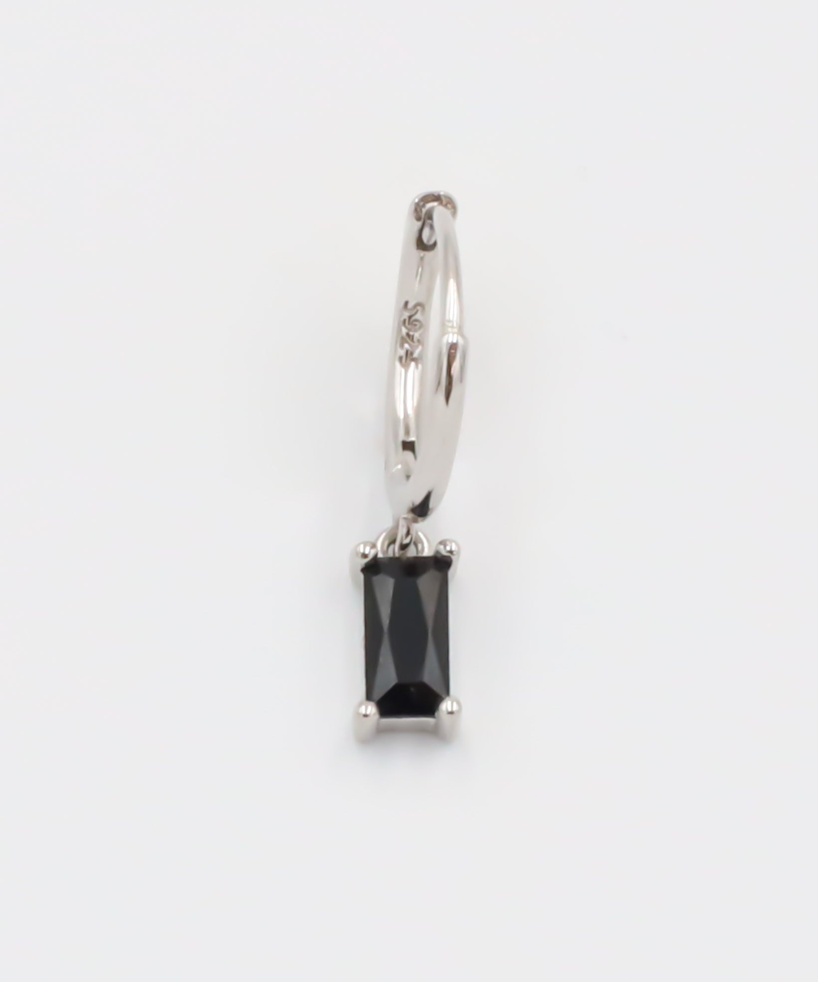 A black and silver colored hoop earring with a hinged clasp.