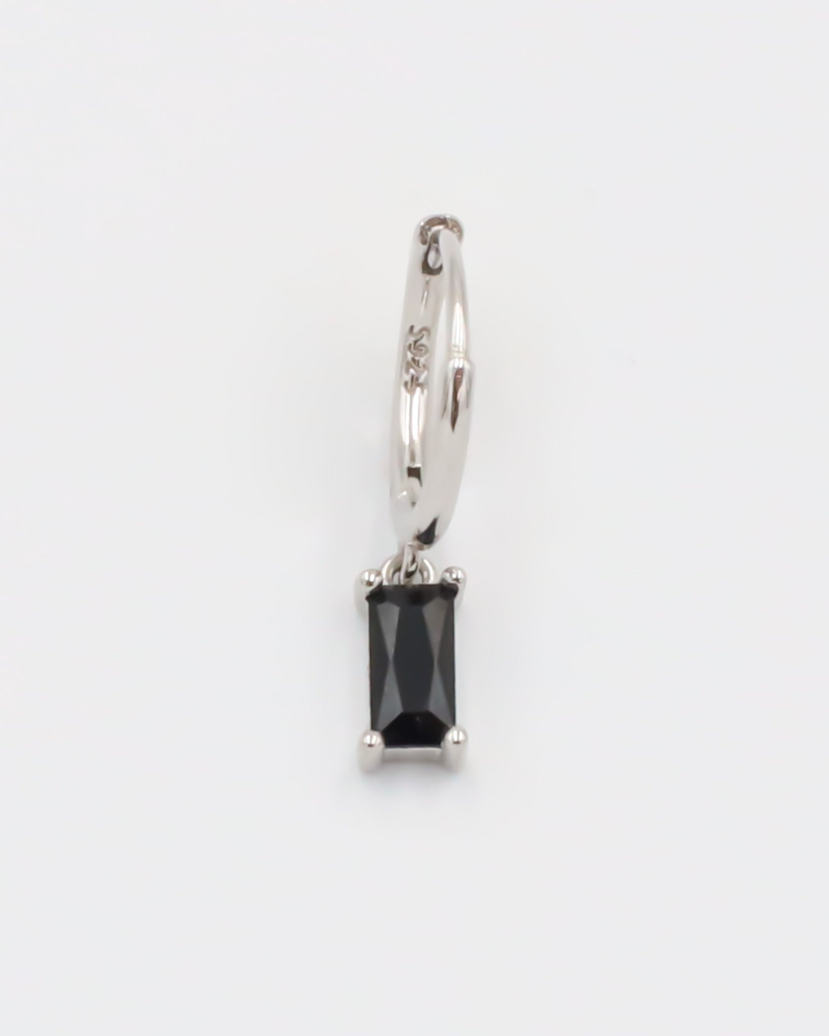 A black and silver colored hoop earring with a hinged clasp.