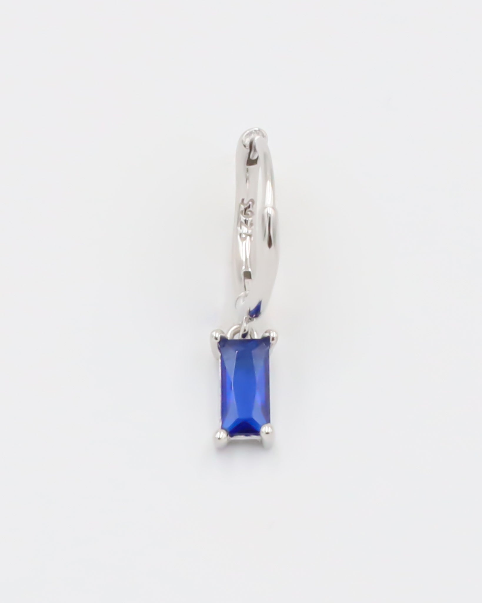 A blue hoop earring with a silver closure mechanism, displayed against a white background.