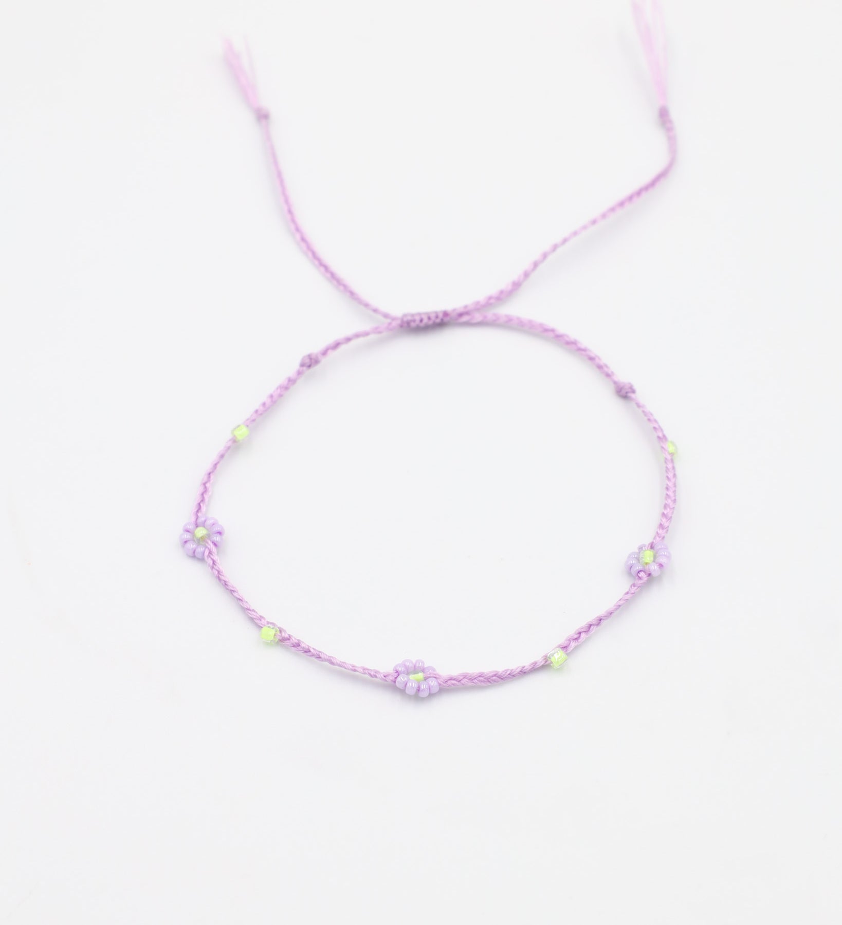 An adjustable gold-colored bracelet featuring a series of round beads and rhinestones, with an emphasis on the flower-shaped design.