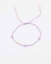 An adjustable gold-colored bracelet featuring a series of round beads and rhinestones, with an emphasis on the flower-shaped design.