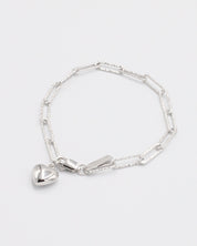A silver bracelet with a heart-shaped charm on a white background.