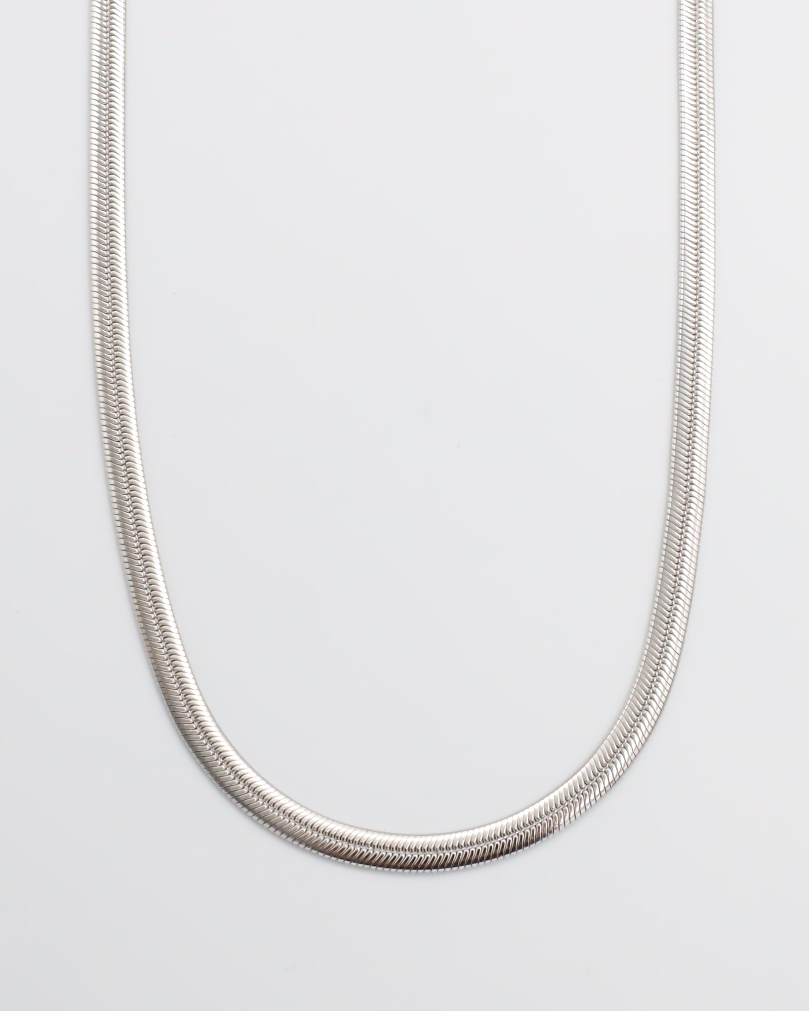 A silver-colored necklace with a metallic texture, displayed against a white background.