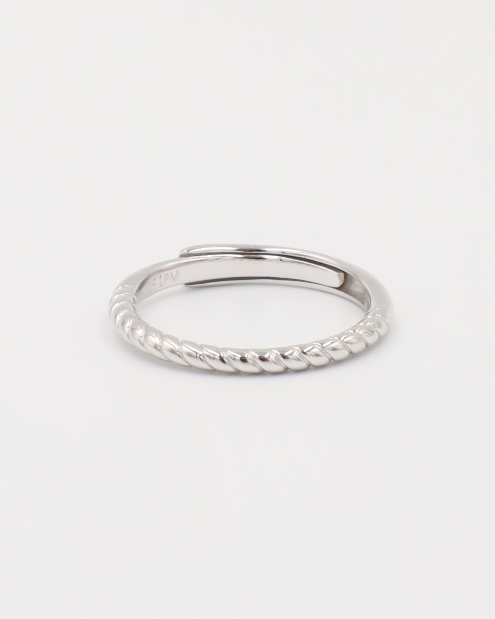 A silver ring with a twisted band design on a white background.