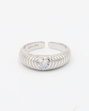 A silver ring with a heart-shaped stone in the center, featuring a textured band and a brightly colored stone.