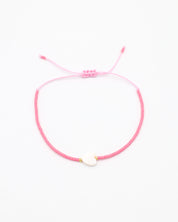 An adjustable pink bracelet with gold accents and a heart-shaped charm.