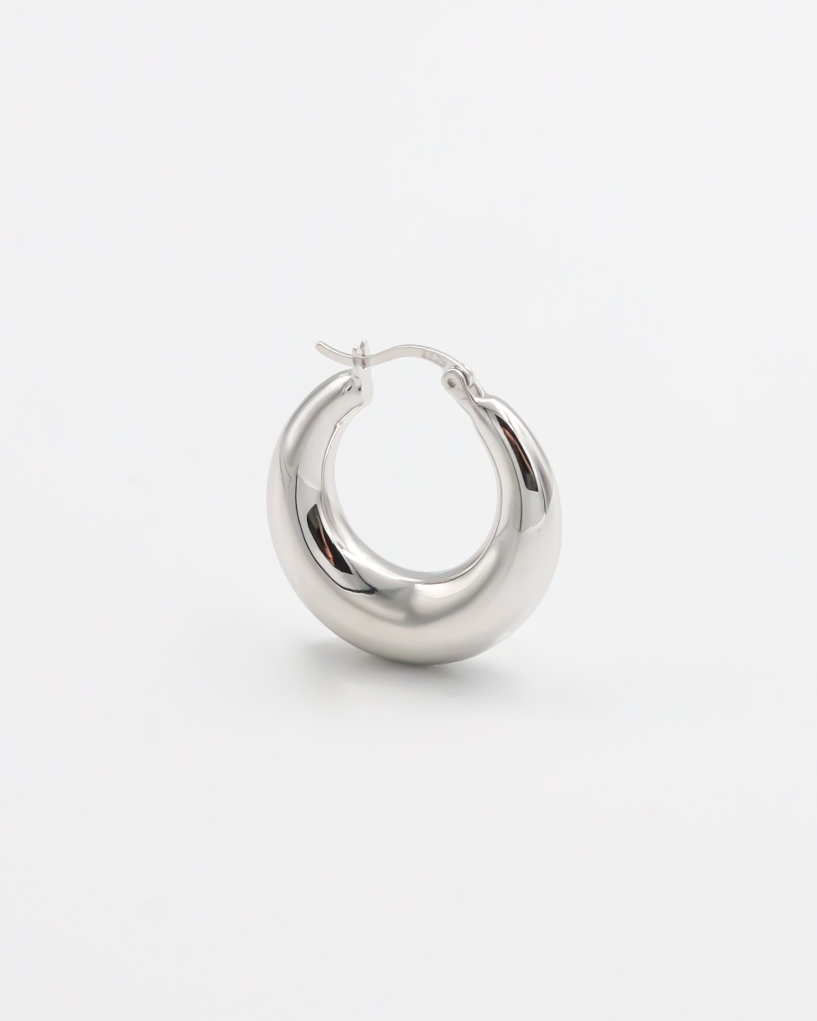 A pair of silver hoop earrings with a latch back closure, displayed against a white background.