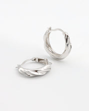 A pair of silver hoop earrings with a latch back closure, displayed on a white background.