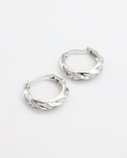 A pair of silver hoop earrings with a latch back closure, displayed on a white background.