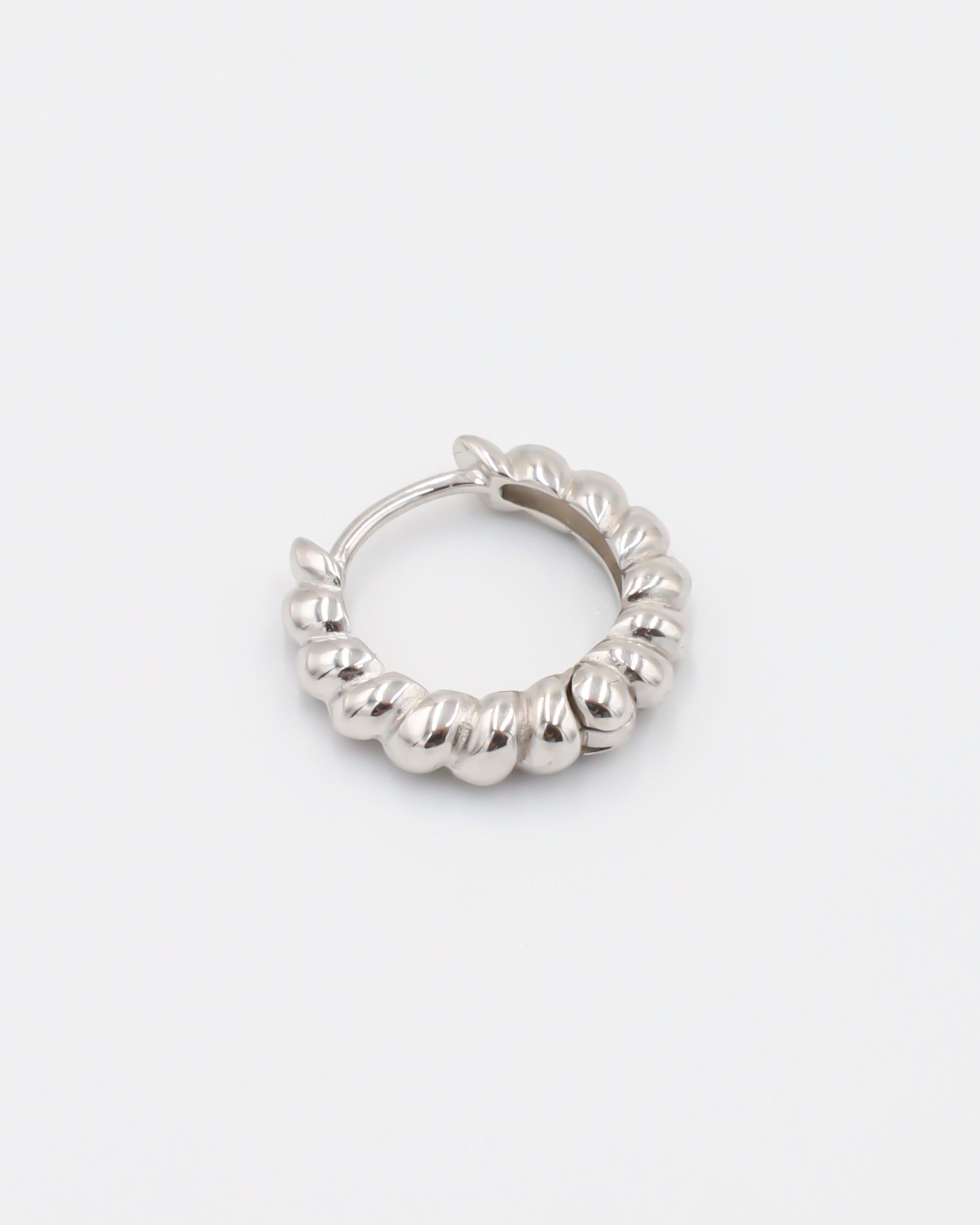 A single silver hoop earring with a hinged clasp, displayed against a white background.