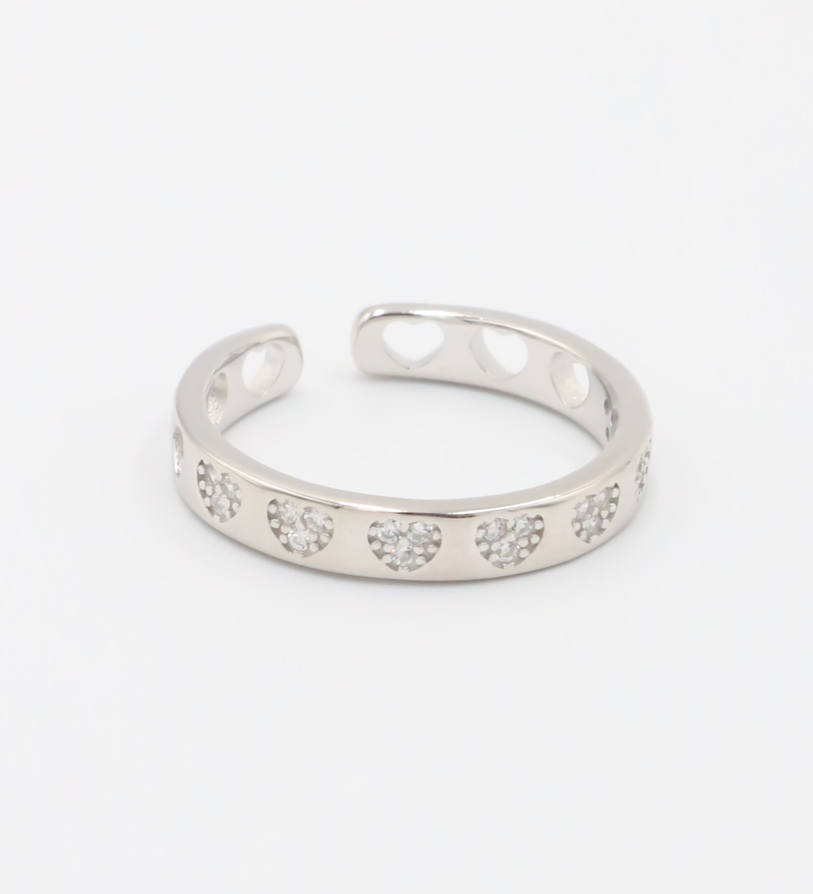 A silver ring with multiple clear stones set in an open band design.