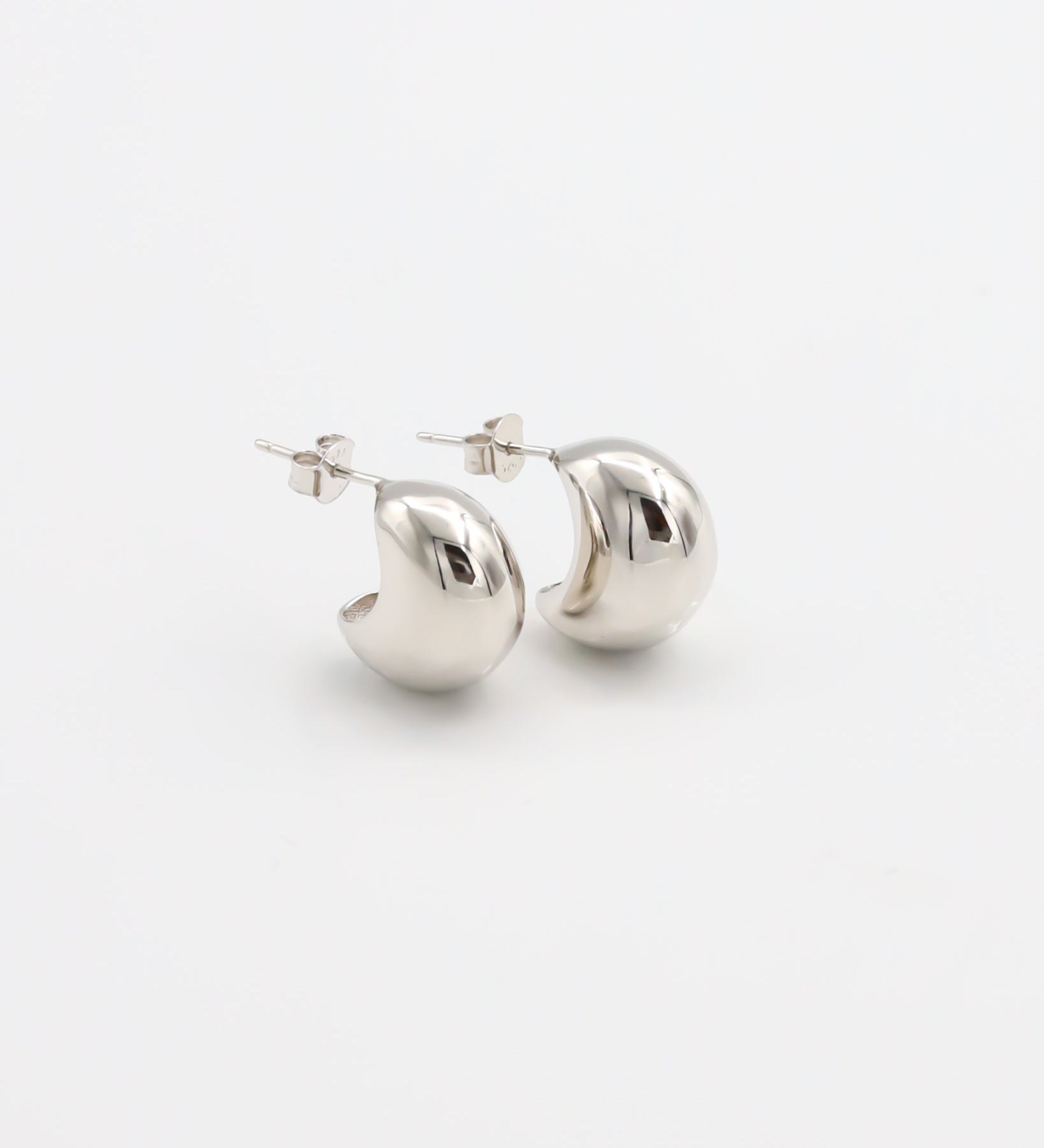 A pair of silver stud earrings with a butterfly closure on a white background.