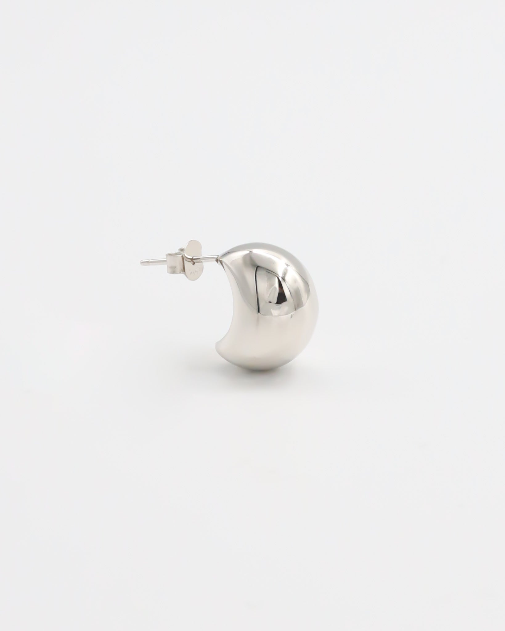 A single silver stud earring with a butterfly closure on a white background.