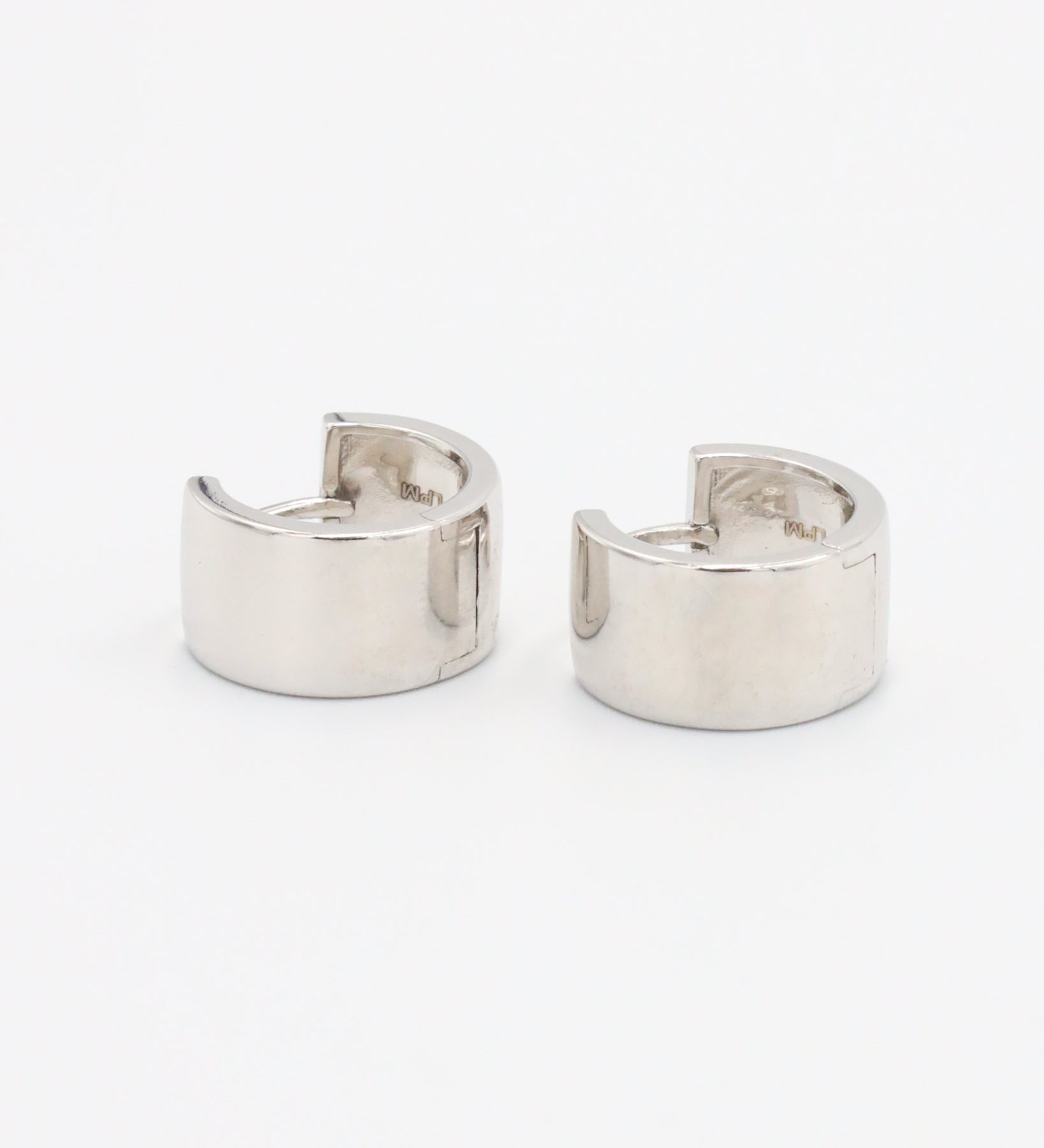 A single silver hoop earring with a hinged clasp, displayed against a white background.