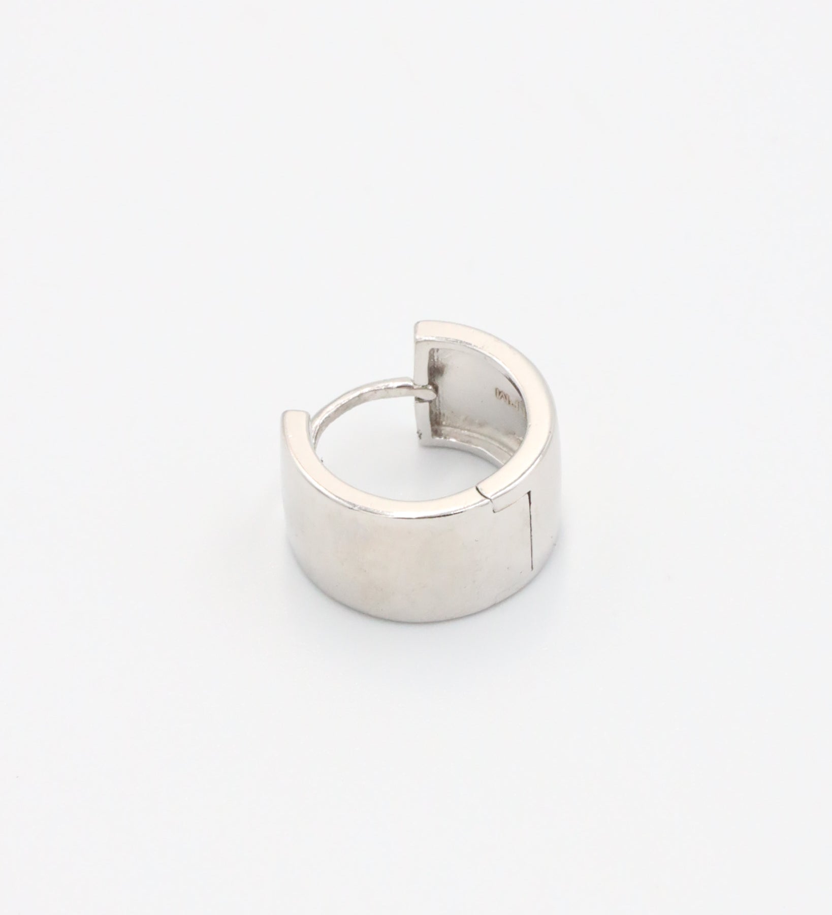 A single silver hoop earring with a hinged clasp, displayed against a white background.