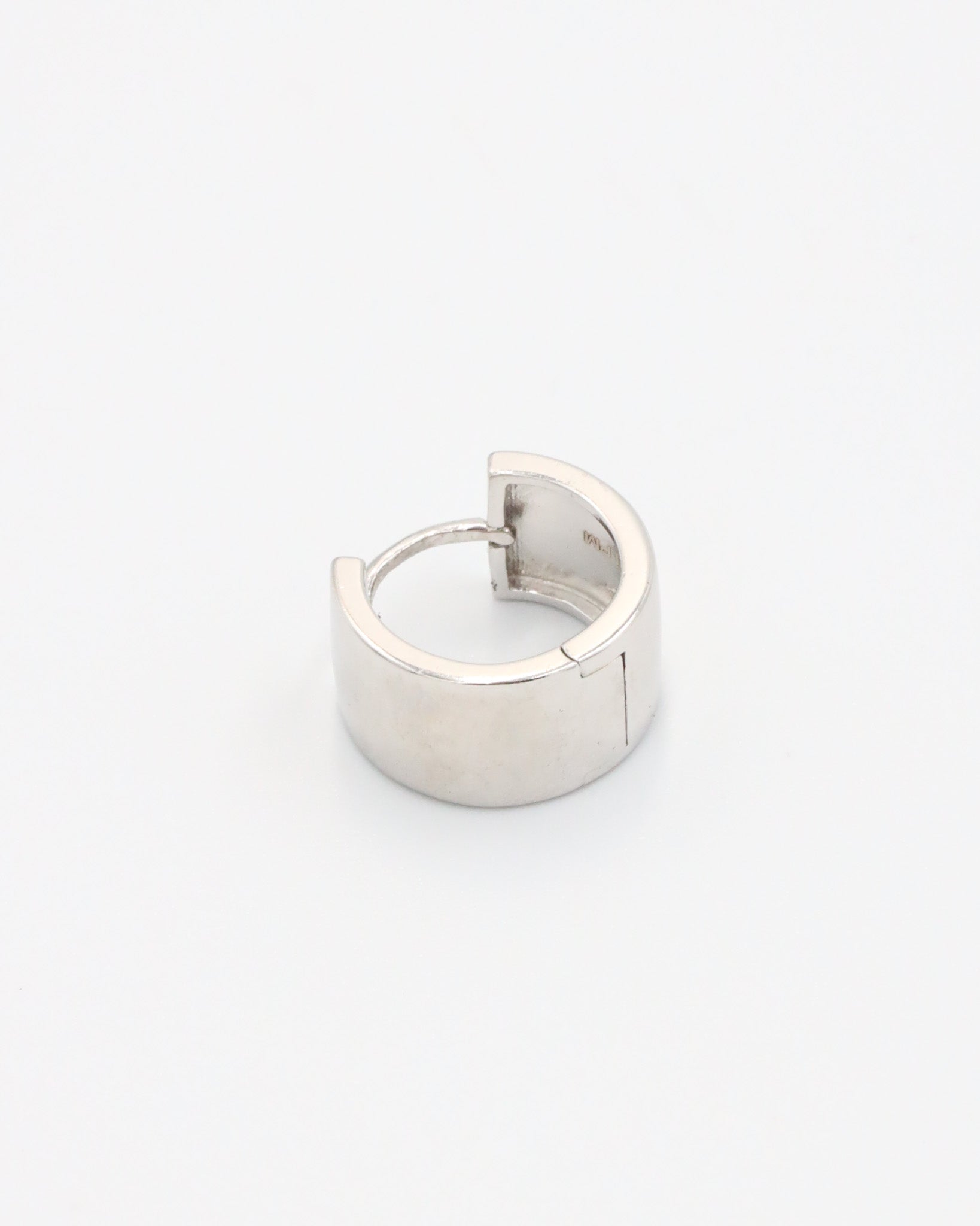 A single silver hoop earring with a hinged clasp, displayed against a white background.