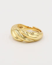 A gold-colored ring with a twisted design on a white background