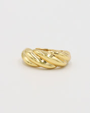 A gold-colored ring with a twisted design on a white background