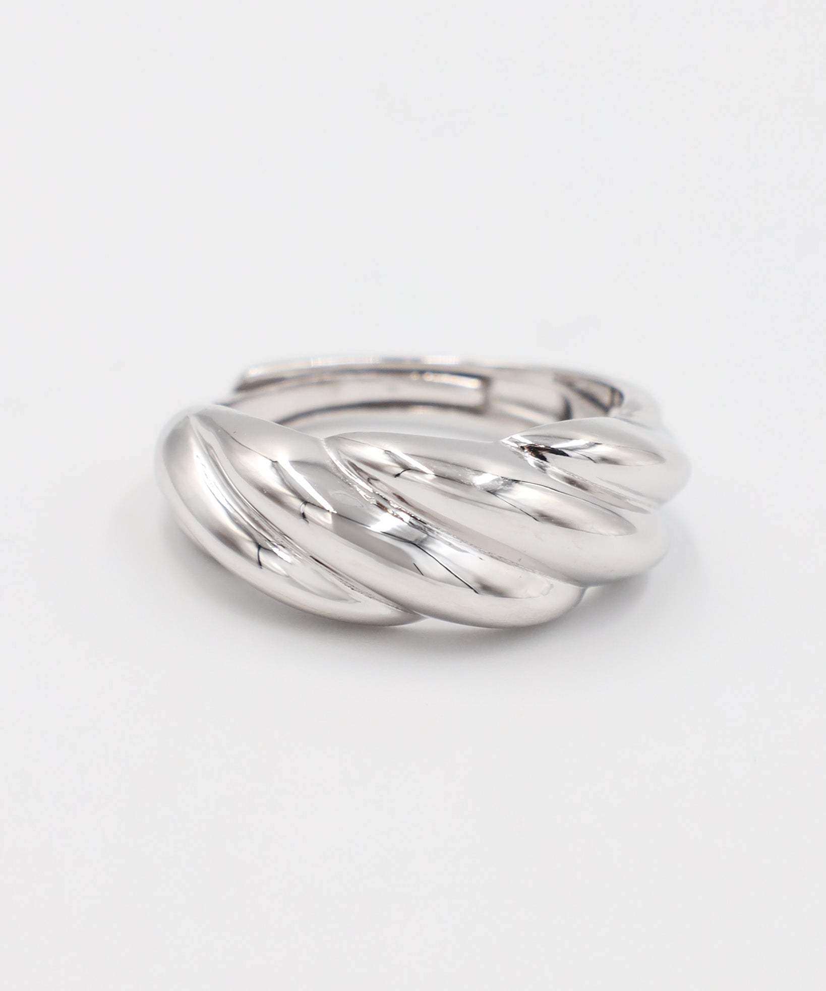 A silver-colored ring with a twisted design on a white background.