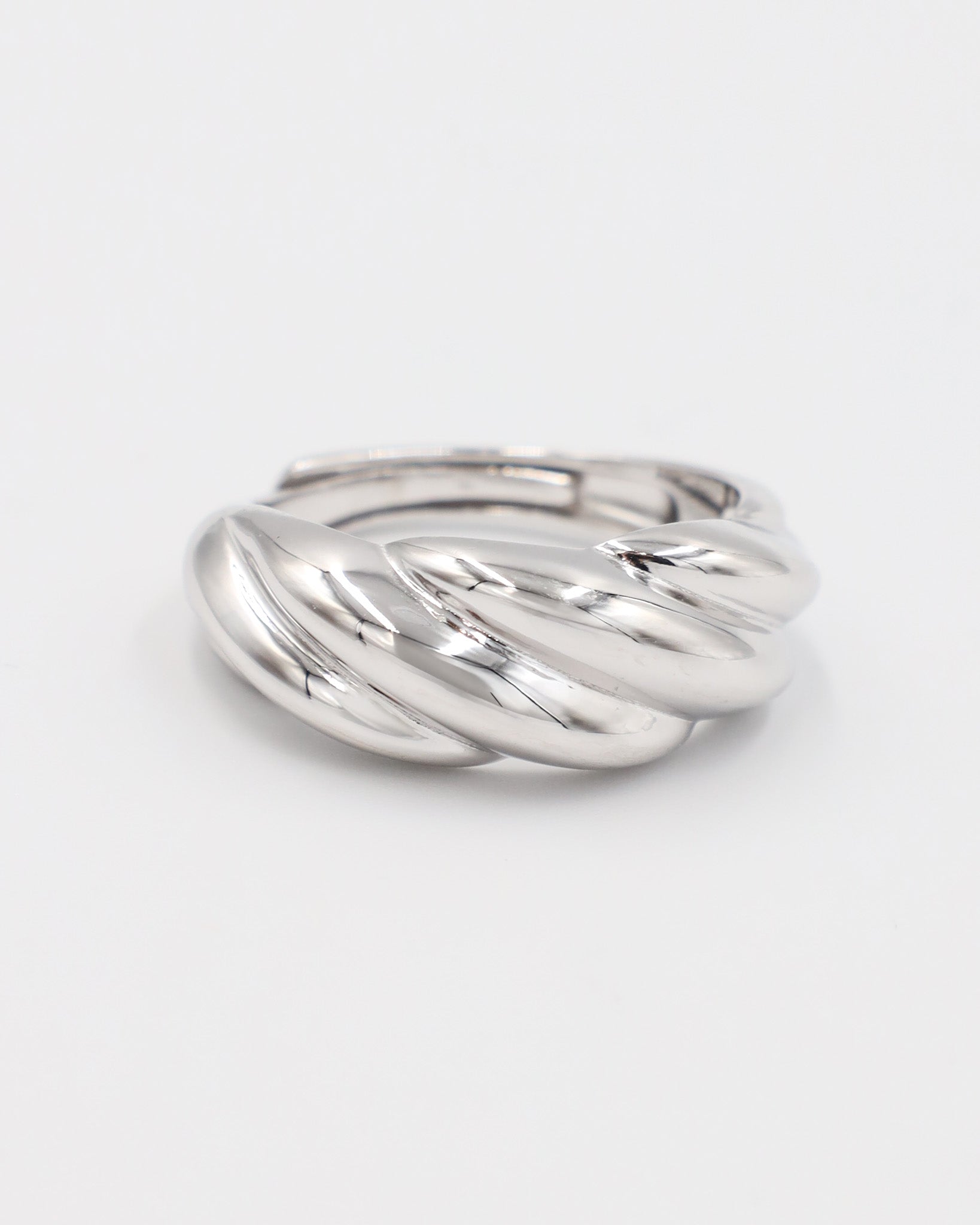 A silver-colored ring with a twisted design on a white background.