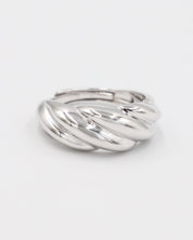 A silver-colored ring with a twisted design on a white background.