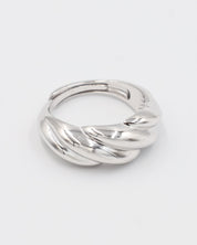 A silver-colored ring with a twisted design on a white background.