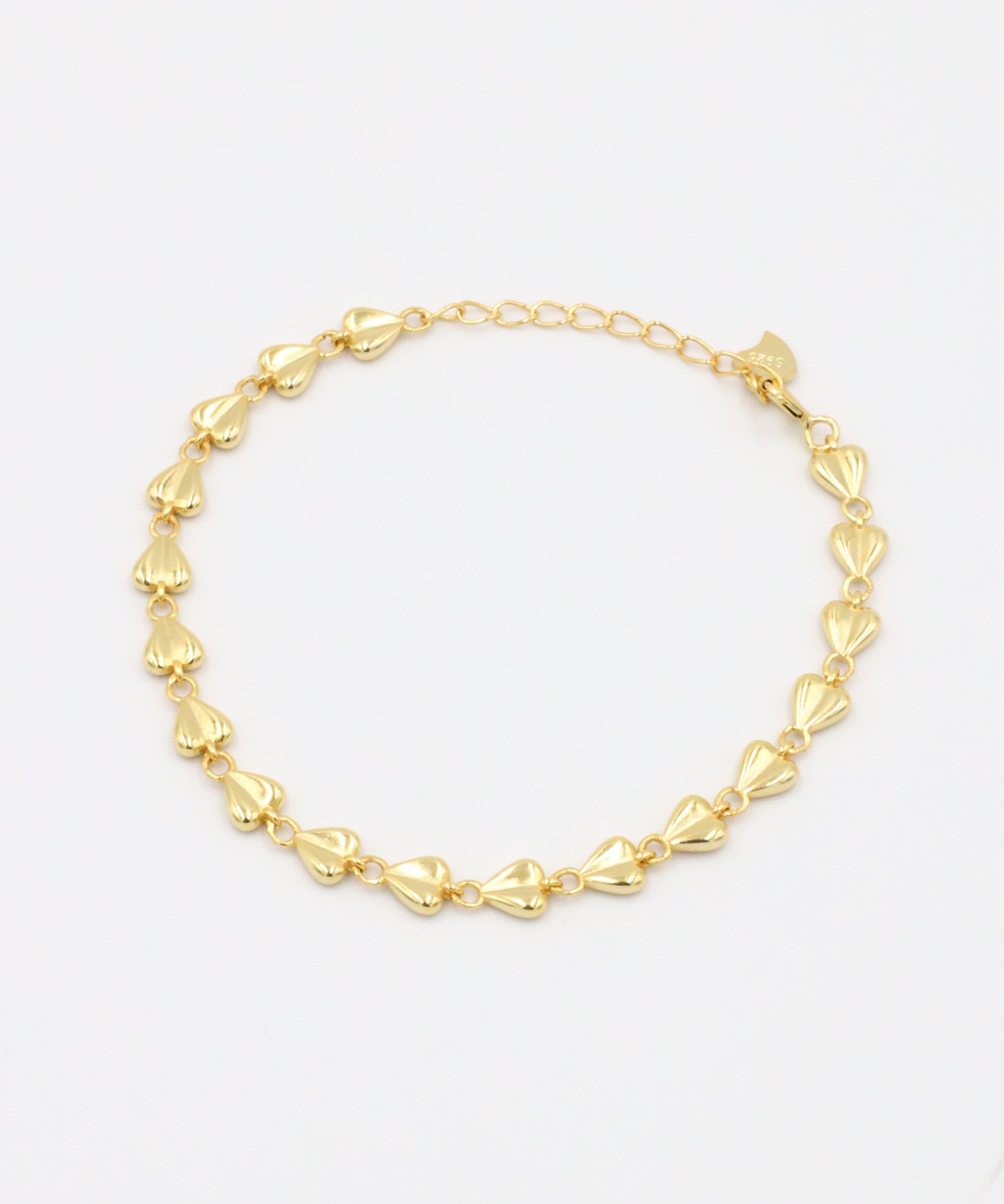 A gold-colored bracelet with a chain link design on a white background