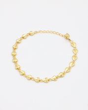 A gold bracelet with a heart-shaped pattern on a white background