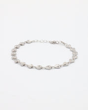 A silver bracelet with a heart-shaped pattern on a white background
