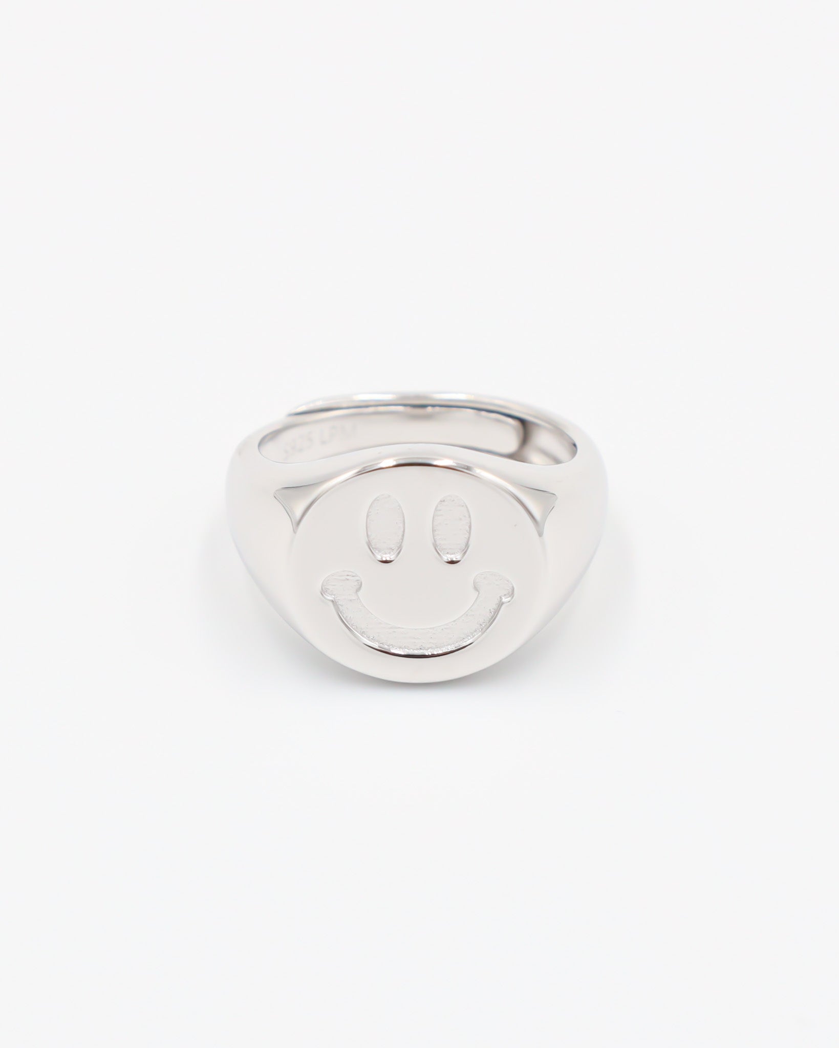 A silver ring with a solid pattern and a rounded band, displayed against a white background.