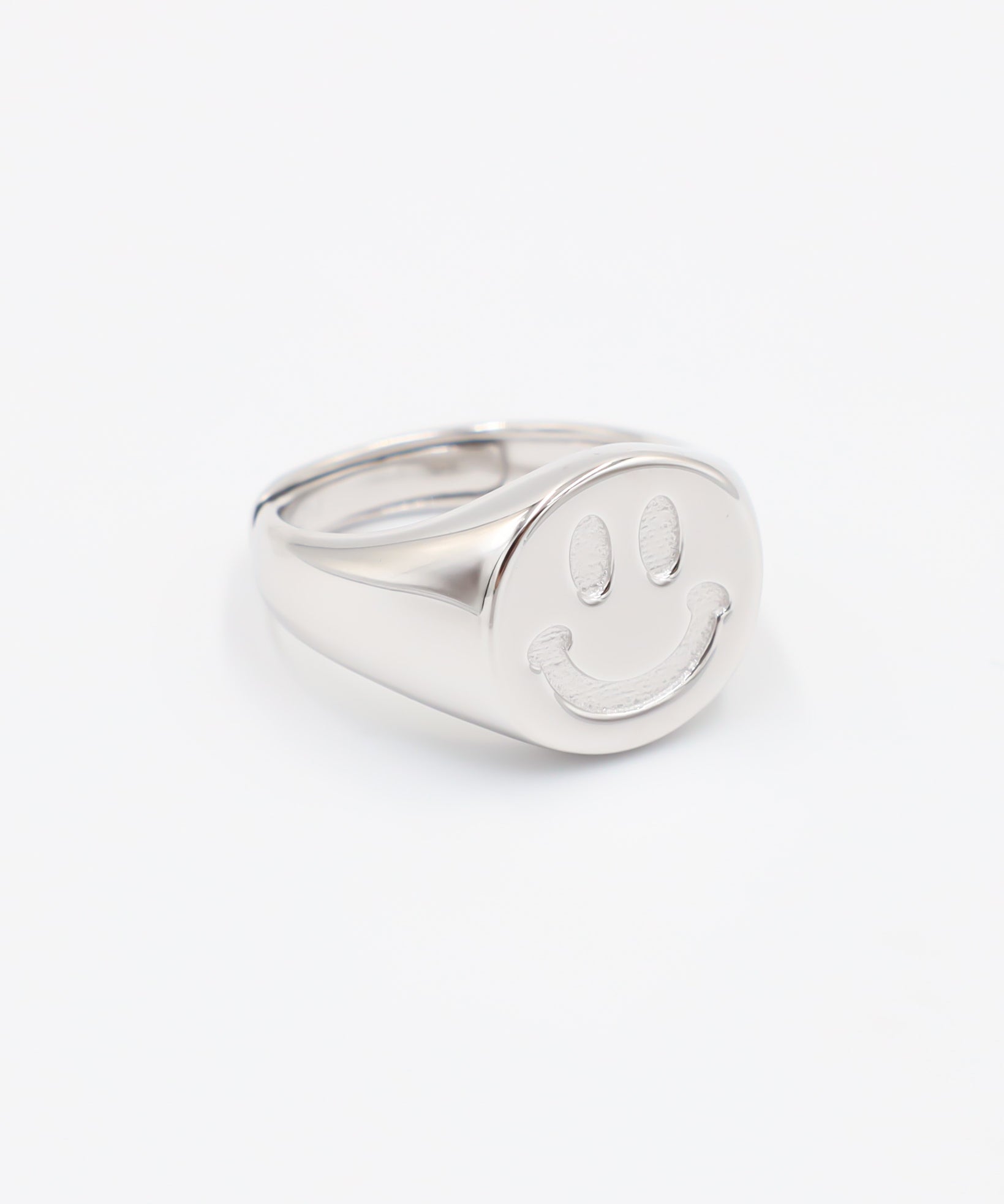 A silver ring with a solid pattern and a rounded band, displayed against a white background.