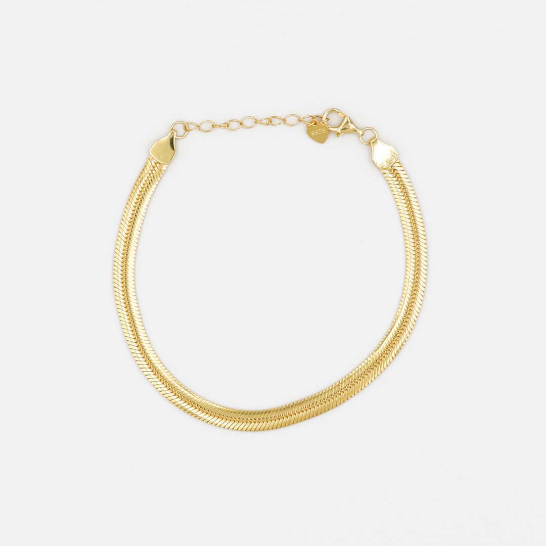 A gold-colored bracelet with a chain link closure on a white background.