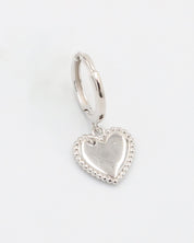 A single silver hoop earrings with heart-shaped pendants attached to them, displayed against a white background.