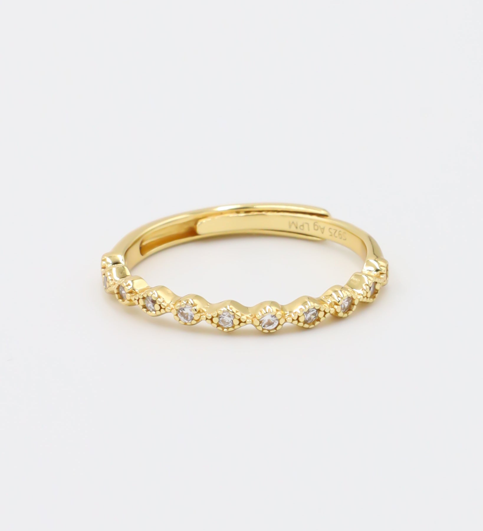 A gold-colored ring with multiple gemstones set around its circumference.
