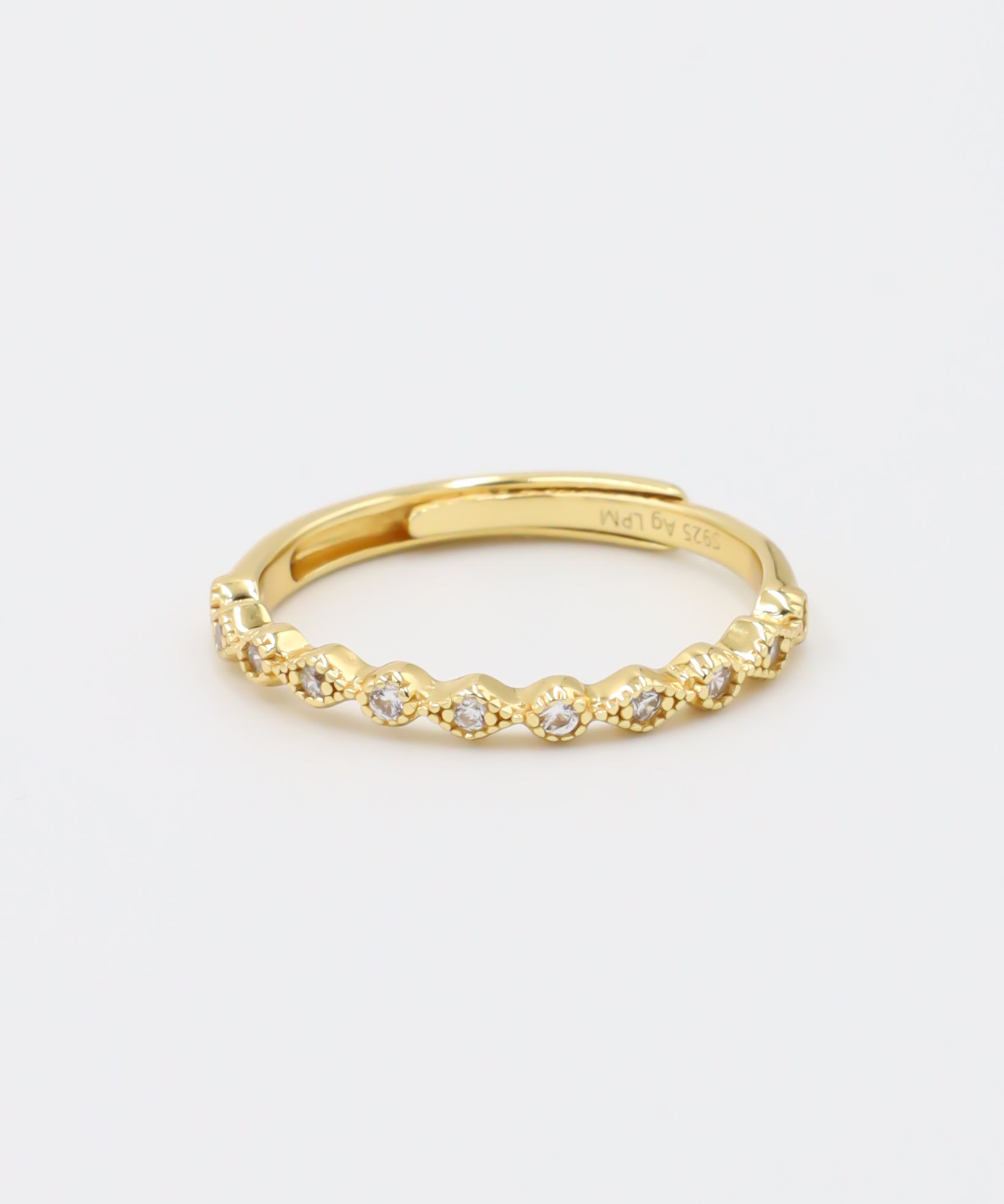 A gold-colored ring with multiple gemstones set around its circumference.