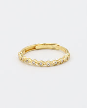 A gold-colored ring with multiple gemstones set around its circumference.