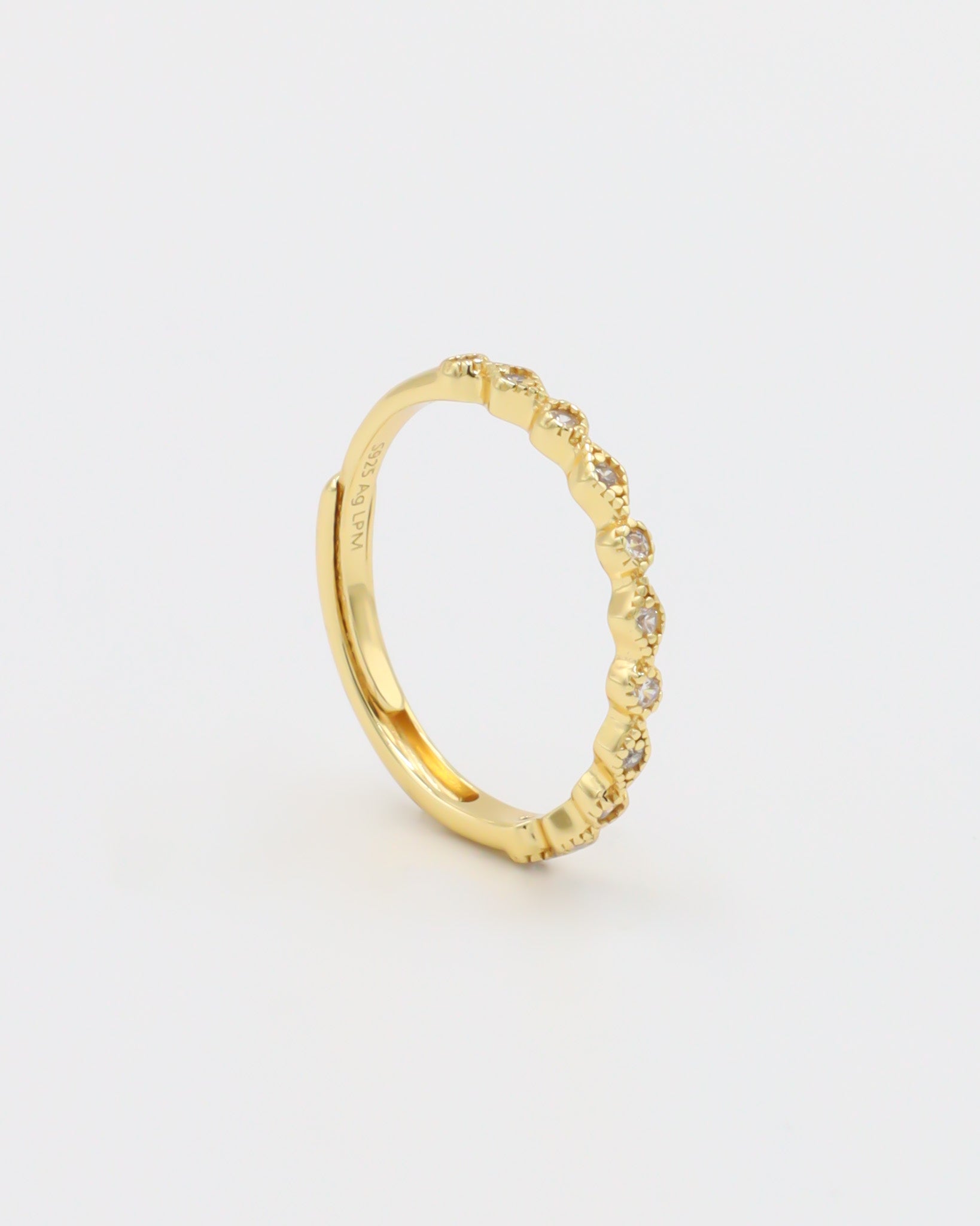 A gold-colored ring with multiple gemstones set around its circumference.