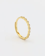 A gold-colored ring with multiple gemstones set around its circumference.
